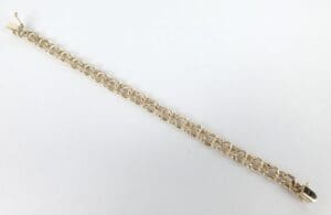 Gold chain bracelet on white background.