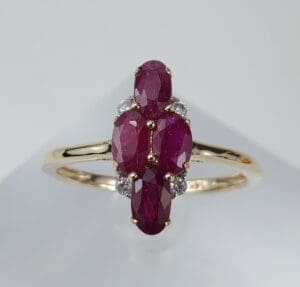 Gold ring with oval red gemstones.