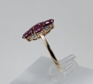 Gold ring with red gemstones displayed.