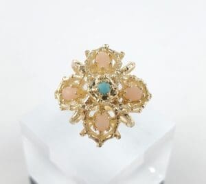 Gold ring with pink and blue stones.