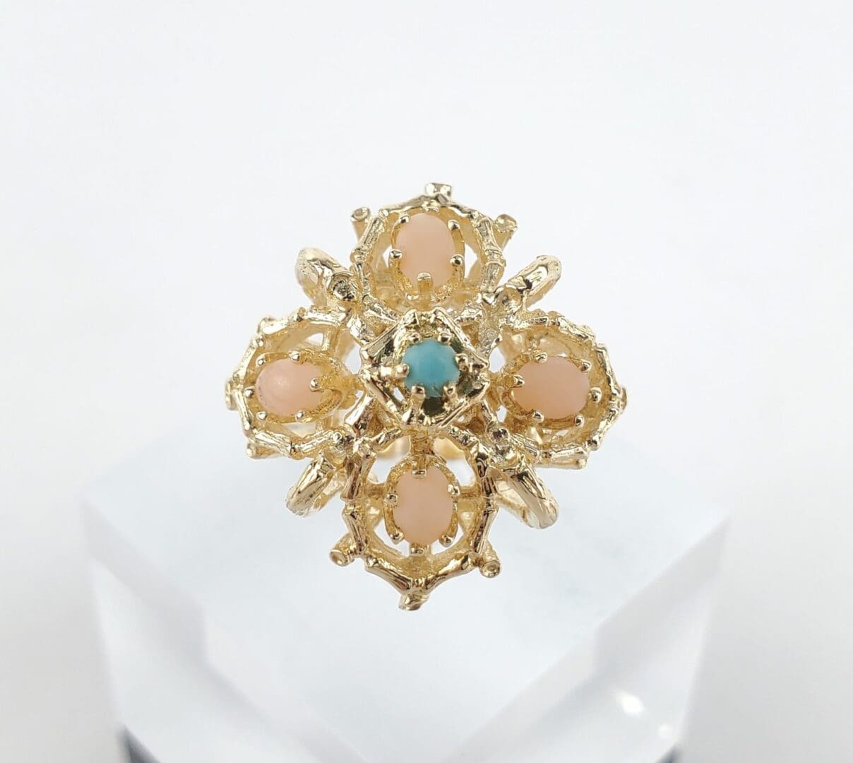 Gold ring with pink and blue stones.