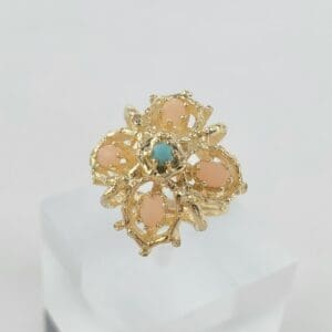 Gold ring with pink and blue stones.