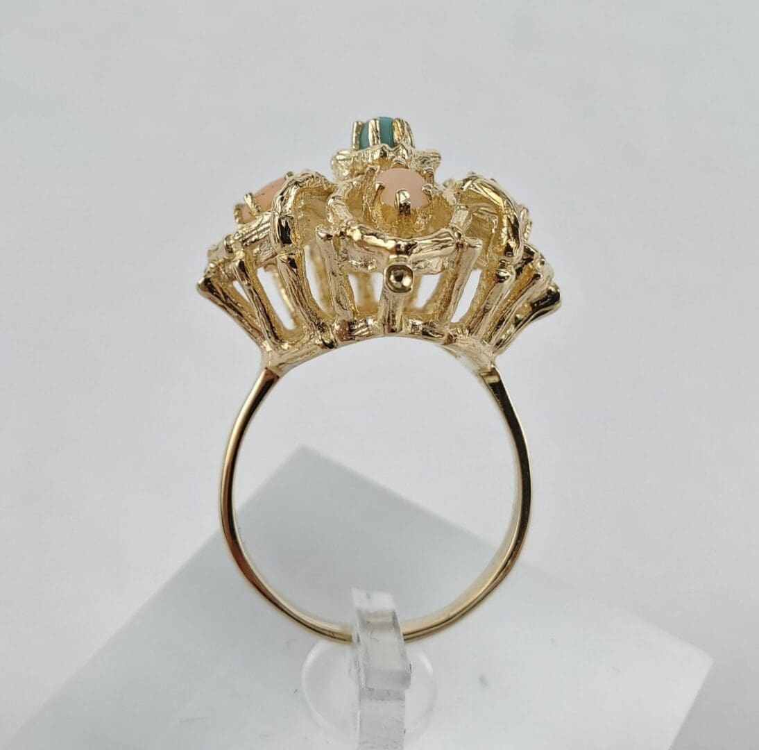 Gold ring with colorful gemstone setting.