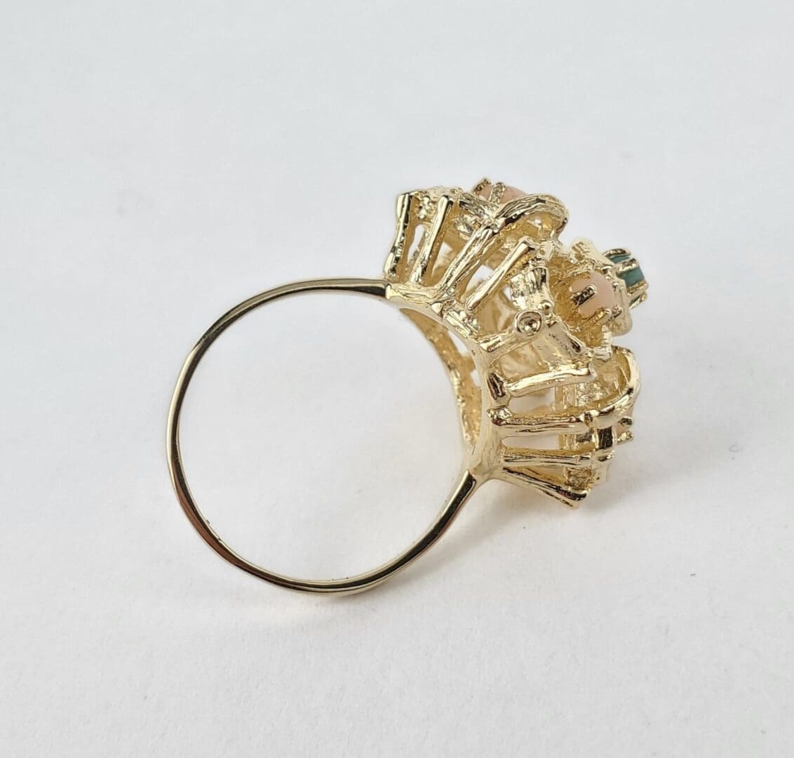 Gold ring with intricate decorative setting.
