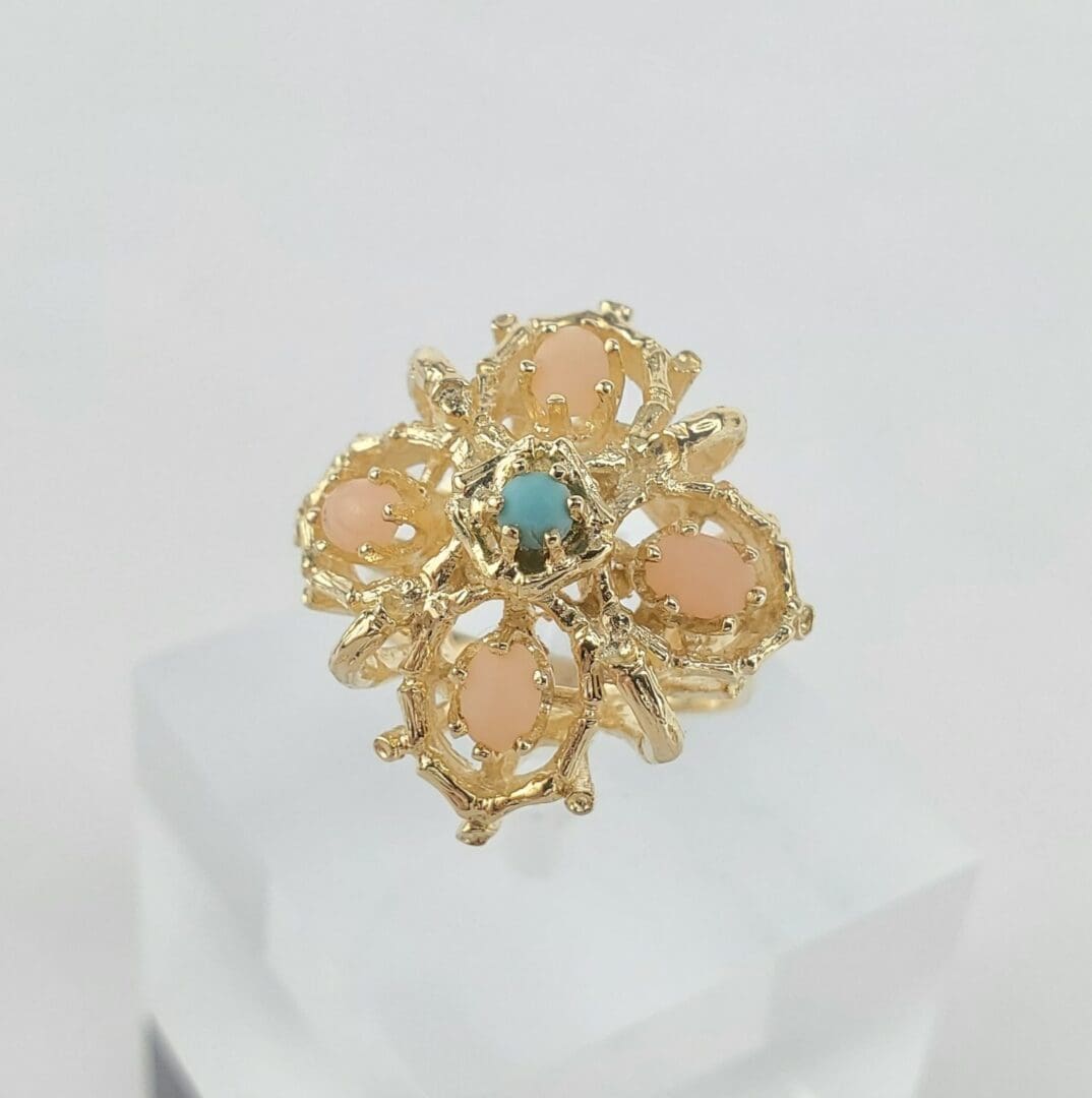 Gold ring with pink and blue stones.