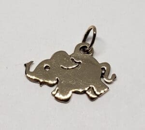 Gold elephant-shaped pendant on white background.