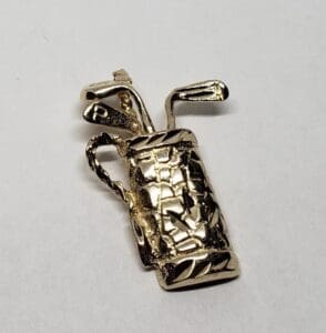 Gold golf bag charm with clubs.