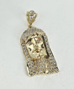 Gold and diamond pendant with face design.