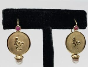 Gold earrings with pink gemstone accents.