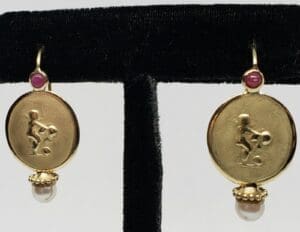 Gold earrings with pearl and ruby accents.