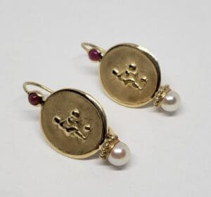 Gold earrings with pearls and red stones.