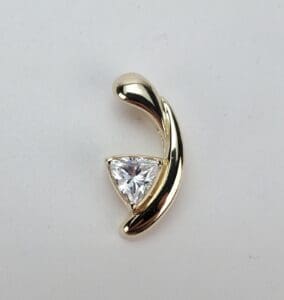 Gold pendant with triangular diamond accent.