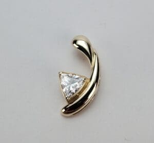 Gold pendant with triangular diamond centerpiece.