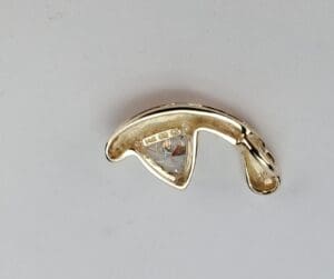 Gold jewelry piece with embedded clear stone.
