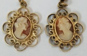 Gold cameo earrings with intricate designs.