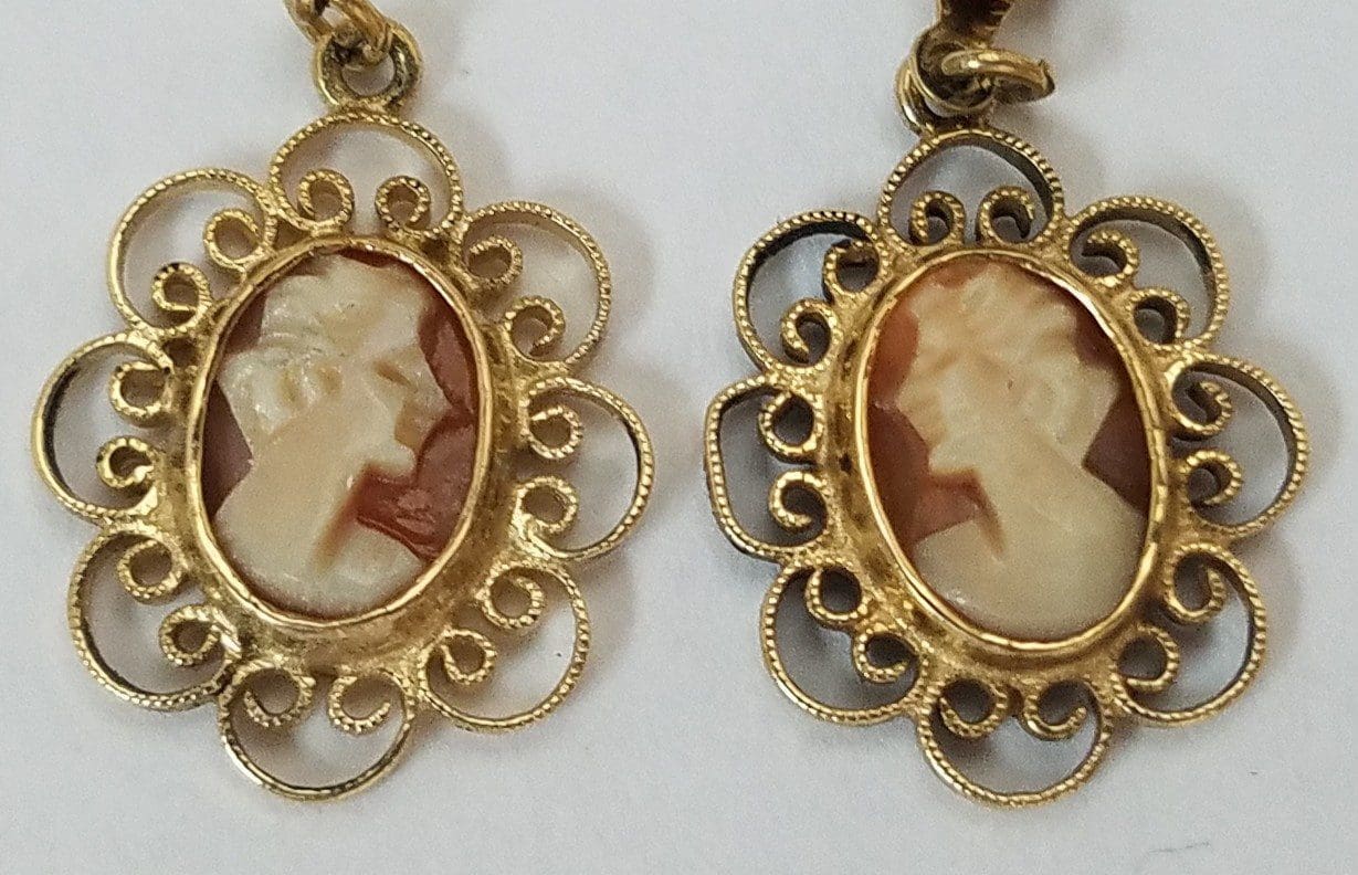 Gold cameo earrings with intricate designs.