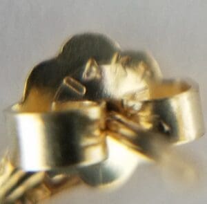 Gold earring back with butterfly clasp.