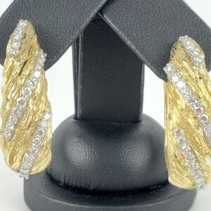 Gold and diamond textured earrings display.