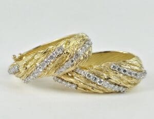 Gold earrings with diamond accents, textured design.