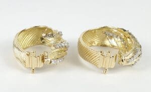 Gold earrings with diamond accents on display.