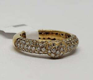 Gold ring with diamond-studded heart design.