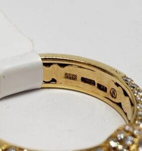 Gold ring with diamond details and hallmark.