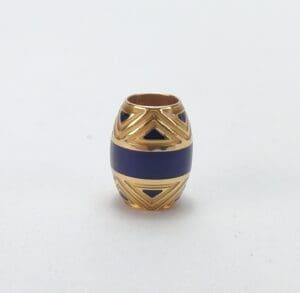 Gold and blue decorative bead on white.