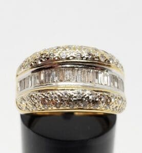 Gold ring with diamonds on black stand.