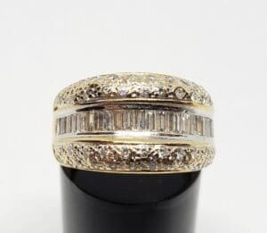 Gold ring with diamonds on black stand.