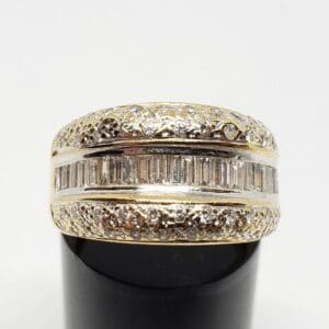 Gold ring with diamonds on black stand.