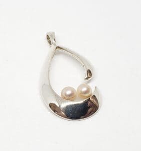 Silver teardrop pendant with two pearls.