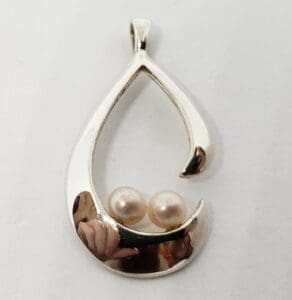 Silver teardrop pendant with two pearls.