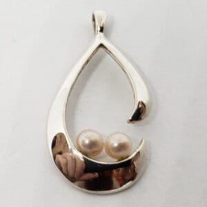 Silver teardrop pendant with two pearls.