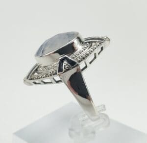 Silver ring with large gemstone and intricate design.