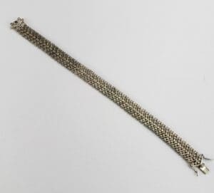 Silver bracelet with intricate woven design.