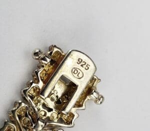 Silver jewelry clasp with "925" stamp detail.