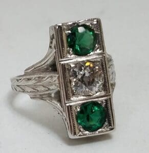 Silver ring with green and clear stones.
