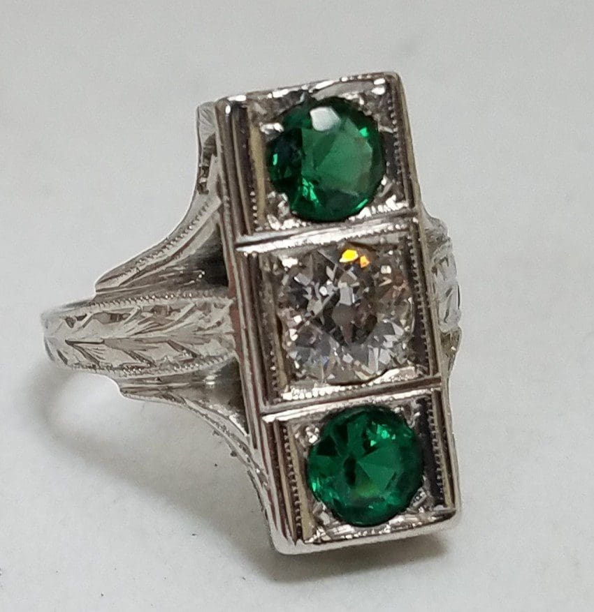 Silver ring with green and clear stones.