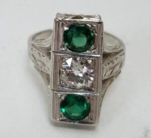 Silver ring with green and clear stones.