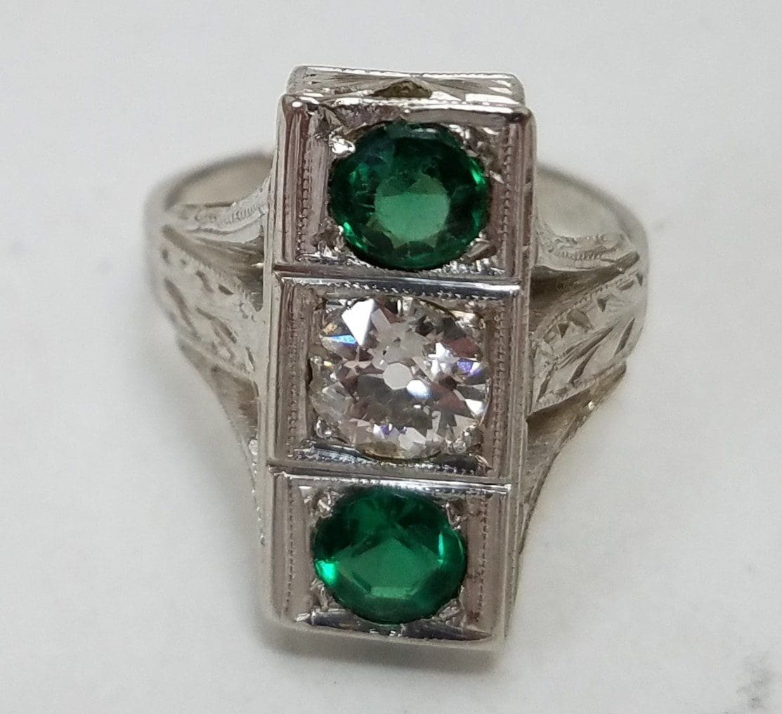 Silver ring with green and clear stones.