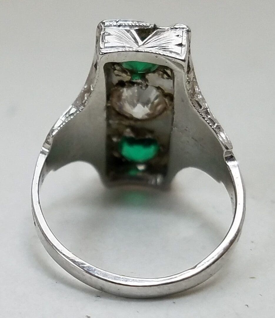 Silver ring with green and clear stones.