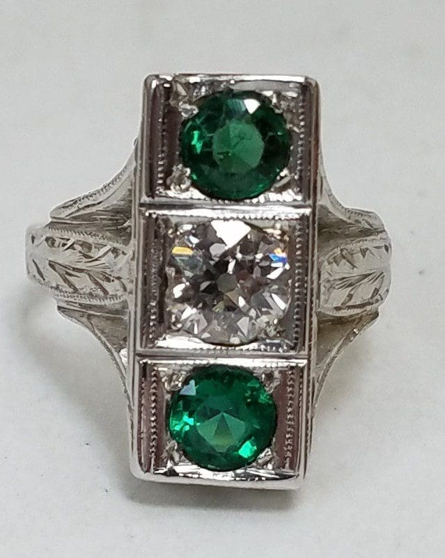 Silver ring with green and clear gemstones.
