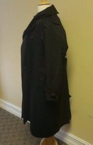 Black trench coat on a mannequin.