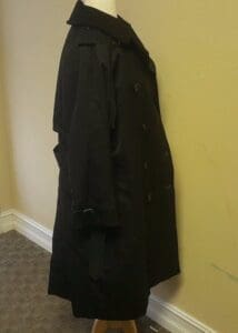 Black coat on mannequin in side view.