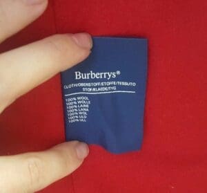 Blue Burberrys label on red fabric.
