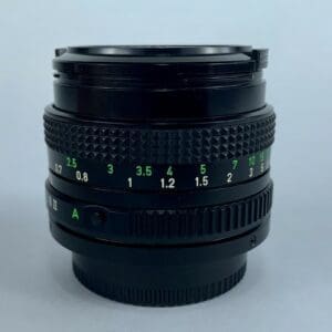 Black camera lens with green focus markings.