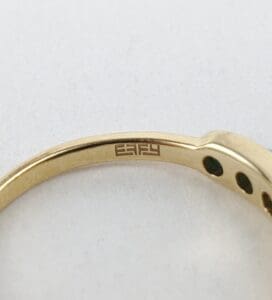 Gold ring with engraved brand logo inside.