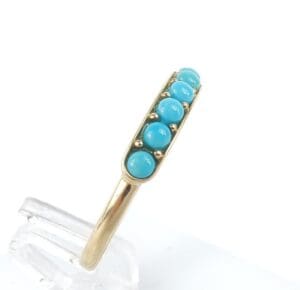 Gold ring with five turquoise stones.