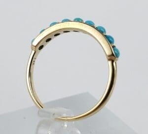 Gold ring with turquoise stones on top.