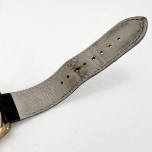 Wristwatch with a worn leather strap.